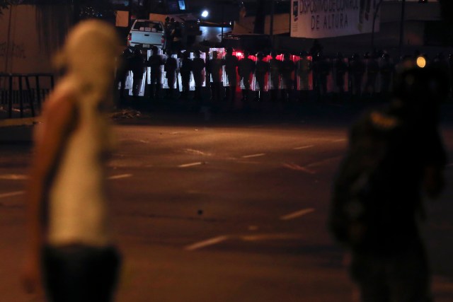 Riot police take position during a clash with anti-government demonstrators at Altamira Square in Caracas