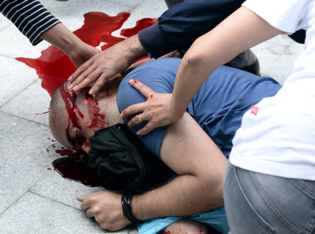Un hombre herido establece inconsciente en un charco de sangre en el suelo durante los enfrentamientos entre manifestantes y la policía antidisturbios en Estambul 22 de mayo 2014 la policía turca disparó gases lacrimógenos para dispersar a los manifestantes que lanzan cócteles molotov y piedras en el distrito de Estambul de Okmeydani el jueves y una persona resultó gravemente herido, la agencia de noticias privada Dogan y otros medios de comunicación informaron. REUTERS / Stringer