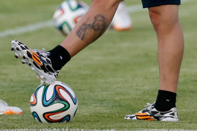 Colombia's national soccer team player James Rodriguez sports a tattoo on his leg as he pauses on the pitch during a training sesion in Fortaleza