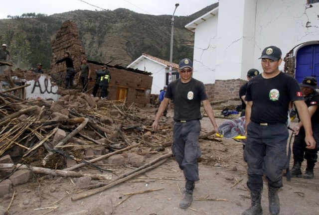 Rescue workers carry the body of a victim of a 5.1 magnitude earthquake that hit Paruro, Cuzco
