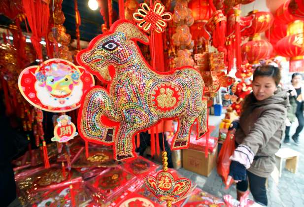 A woman gestures at a stall selling decorations ahead of the upcoming Spring Festival in Wuhan