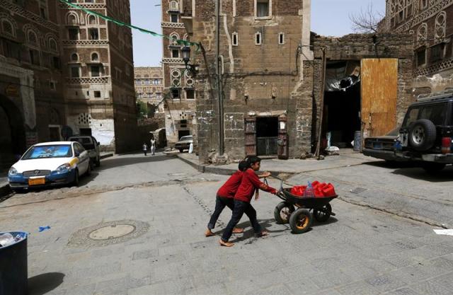 Dos niños yemeníes trasladan una carretilla llena de bidones de agua en Saná, Yemen, hoy, martes 14 de abril de 2015. La situación humanitaria en el Yemen empeora por el conflicto armado y los bombardeos de la coalición árabe, mientras que las organizaciones internacionales intentan hacer llegar la ayuda médica a las ciudades afectadas. EFE/Yahya Arhab