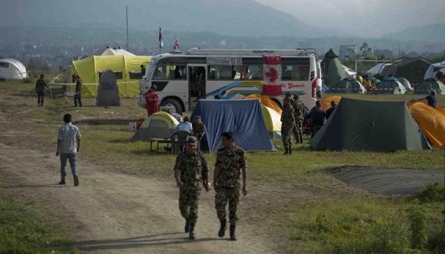 Varios soldados caminan por el campamento en el que se alojan miembros de los equipos de búsqueda y rescate que continúan con sus labores en Katmandú (Nepal) hoy, jueves 30 de abril de 2015. El último recuento oficial de víctimas por el terremoto de 7,8 grados que sacudió Nepal el sábado eleva a casi 5.500 el número de muertos y a 11.000 el de heridos, mientras miles de vehículos continúan huyendo de Katmandú hacia zonas más seguras. EFE/Will Oliver