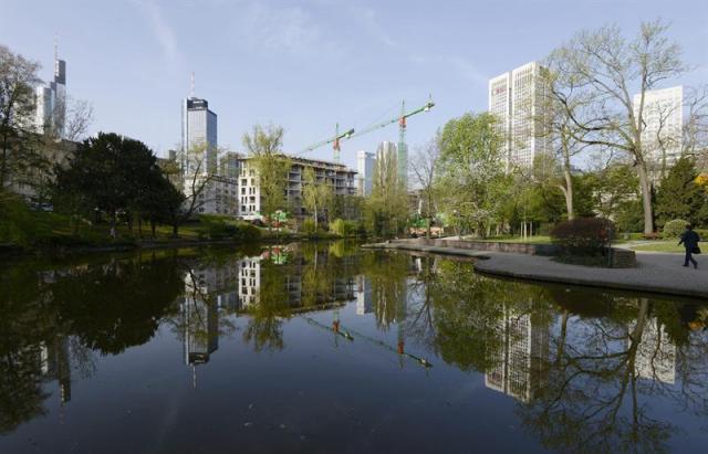 Un peatón (d) se dirige a su lugar de trabajo en Fráncfort (Alemania) hoy, jueves 16 de abril de 2015. Los principales institutos de estudios económicos alemanes han revisado al alza el pronóstico de crecimiento del PIB de Alemania para 2015 y creen que tendrá un fuerte repunte, impulsado ante todo por el consumo privado. Según el informe conjunto de los institutos DIW de Berlín, IFO de Múnich, IWH de Halle y RWI de Colonia, que se presenta hoy y ha sido adelantado por varios medios alemanes, el producto interior bruto (PIB) alemán crecerá este año un 2,1 % y en 2016 un 1,8 %. El pronóstico de crecimiento del informe otoñal para este año era del 1,2 %. Sin embargo, la eficiencia de la economía alemana se ve limitada en una comparación internacional por las excesivas cargas fiscales para los trabajadores. EFE/Mauritz Antin