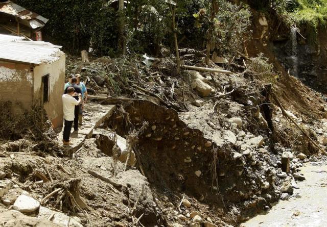  Integrantes de una familia retornan a su casa hoy, miércoles 20 de mayo de 2015 en Salgar (Colombia). La zona asolada este lunes por una avalancha en los alrededores del pueblo colombiano de Salgar (noroeste), que dejó 83 muertos y un número indeterminado de desaparecidos, fue de nuevo desalojada hoy ante el temor de que se produjera otro alud, informaron a Efe bomberos en el área. Tras el desalojo temporal, se descartó la posibilidad de que hubiera una nueva avalancha, si bien se mantiene un control y monitoreo de la zona para prevenir otra tragedia, añadieron las fuentes. EFE/LUIS EDUARDO NORIEGA