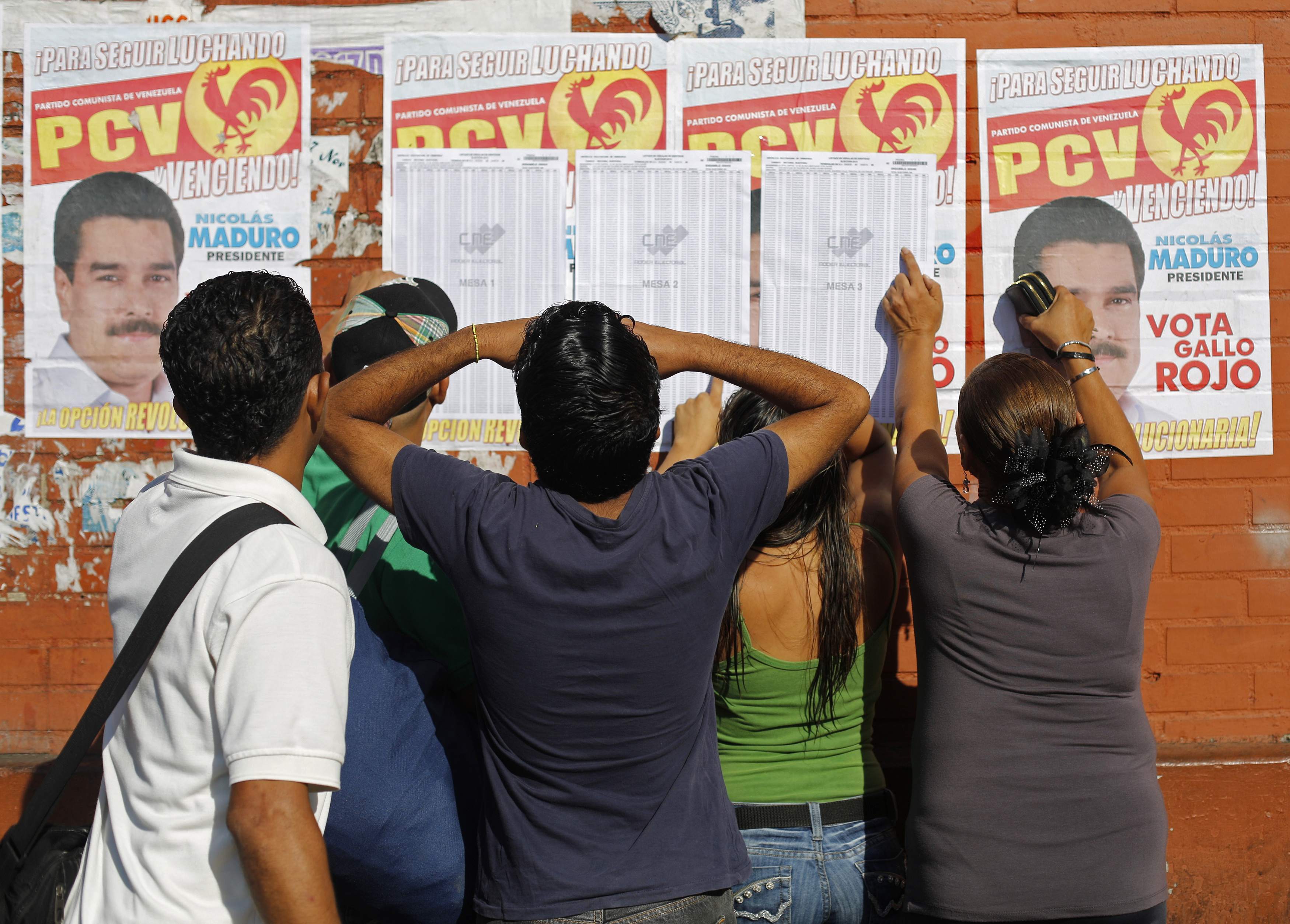 Venezolanos buscándose en listas electorales y de fondo propaganda de Maduro (Foto)