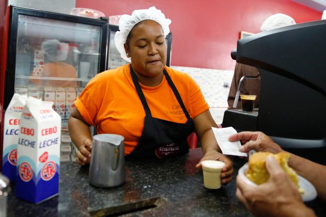 A woman serves coffee at a state-run Cafe Venezuela in Caracas