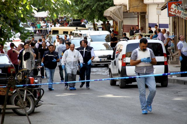 Police forensic experts examine the street following an attack on police officers in Diyarbakir, Turkey, July 23, 2015.  A Turkish police officer was shot and killed and a second wounded on Thursday in the mainly Kurdish city of Diyarbakir in the latest in a series of attacks that began with a suicide bombing blamed on Islamic State, security sources said. The shooting, which occurred in the centre of Diyarbakir, comes one day after two police officers were killed in an attack in Ceylanpinar on the Syrian border for which militants from the Kurdistan Workers Party (PKK) claimed responsibility. REUTERS/Sertac Kayar