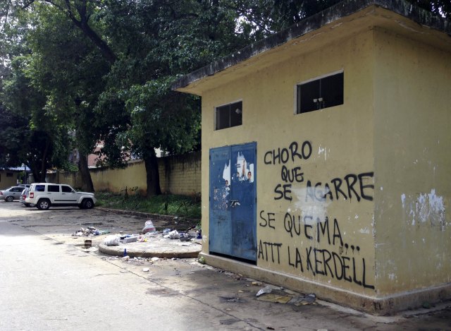 A graffiti that reads "Get ready, thief, here we burn you. Regards, Kerdell" is seen at a residential block in Valencia, Venezuela, August 21, 2015. When a man they believed to be a thief sneaked into their parking lot in the Venezuelan city of Valencia, angry residents caught him, stripped him and beat him with fists, sticks and stones. They tied him up and doused him in gasoline, according to witnesses, in one of what rights groups and media reports say are an increasing number of mob beatings and lynchings in a country ravaged by crime. Picture taken on August 21, 2015. REUTERS/Alexandra Ulmer