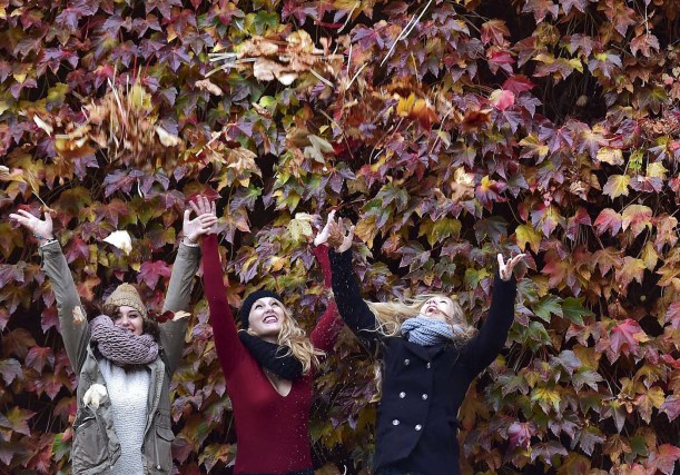 Women enjoy themselves in the autumn foliage in central London, November 7, 2015. REUTERS/Toby Melville