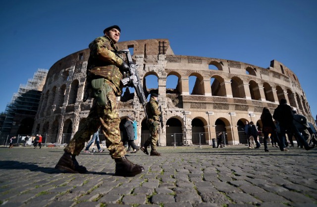 Soldados patrullan cerca del Coliseo el 25 de noviembre de 2015, de Roma. Italia es pasar un adicional de mil millones de euros (1060 millones) en materia de seguridad, el primer ministro italiano Matteo Renzi ha anunciado hoy. En un discurso en el ayuntamiento de Roma, dijo a 500 millones de euros se destinarían a la seguridad cibernética y la modernización de la policía, y 500 millones de dólares para las fuerzas armadas italianas. AFP PHOTO / FILIPPO MONTEFORTE