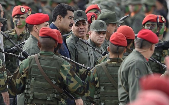 Venezuelan President Nicolas Maduro (C-L) walks with Venezuelan Defense Minister Padrino Lopez (C-R) during a military parade in Caracas on December 12, 2015. Maduro asked Saturday the Armed Forces to get ready for an "unconventional war", as he promised job betterments for the military. AFP PHOTO/JUAN BARRETO / AFP / JUAN BARRETO