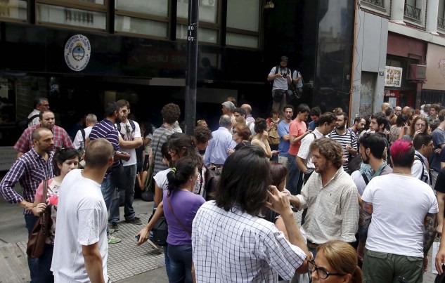 People gather outside the Federal Authority on Audio Visual Communications Services (AFSCA) headquarters in Buenos Aires, December 23, 2015. Argentina's new government fired Martin Sabbatella, the country's chief media regulator, on Wednesday, saying the head of the AFSCA television and radio watchdog commission was openly acting against the country's new center-right President Mauricio Macri. REUTERS/Enrique Marcarian