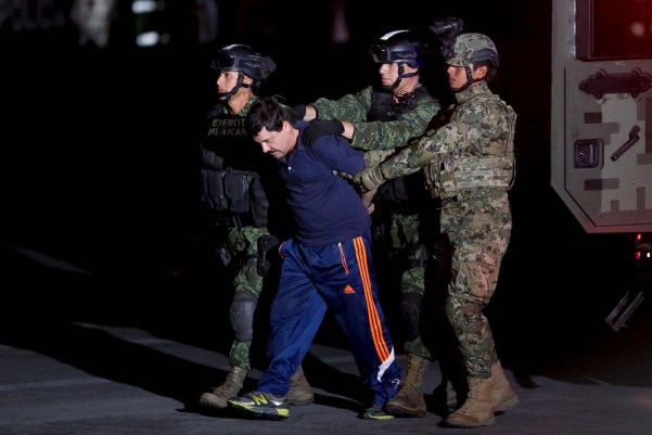 Drug lord Joaquin "El Chapo" Guzman is escorted by soldiers during a presentation in Mexico City, January 8, 2016. REUTERS/Tomas Bravo      TPX IMAGES OF THE DAY