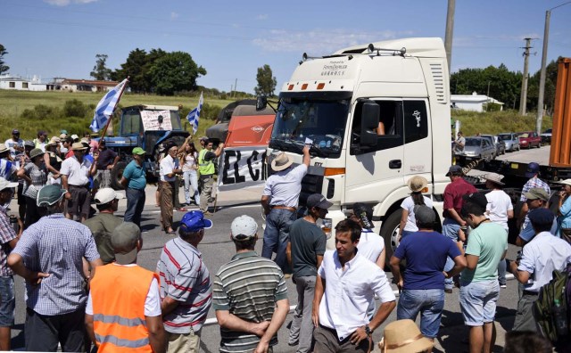 Productores lecheros bloquean una carretera principal contra los aumentos de precios en los servicios públicos y exigiendo el pago de unos 100 millones de dólares que Venezuela adeduda al sector   (AP Foto/Matilde Campodonico)