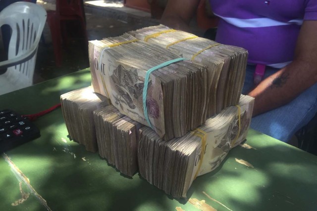 Venezuela's local currency lies on a currency trader's table in the border town of Maicao, Colombia August 18, 2015. Driven by a deepening economic crisis, smuggling across Venezuela's land and maritime borders - as well as illicit domestic trading - has accelerated to unprecedented levels and is transforming society. Although smuggling has a centuries-old history here, the socialist government's generous subsidies and a currency collapse have given it a dramatic new impetus. To match Insight VENEZUELA-SMUGGLING/ Picture taken August 18, 2015. REUTERS/Girish Gupta
