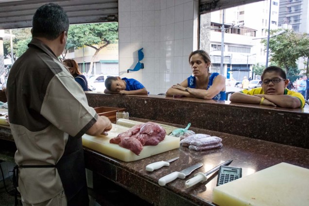 CAR04. CARACAS (VENEZUELA), 11/02/2016.- Un carnicero atiende a sus clientes hoy, jueves 11 de febrero de 2016, en Caracas (Venezuela). El Parlamento venezolano declaró hoy la "crisis alimentaria nacional" y en virtud de ello pidió que la FAO y la Unicef envíen expertos que evalúen los riesgos que entraña el problema para los 30 millones de habitantes del país caribeño. EFE/Miguel Gutiérrez