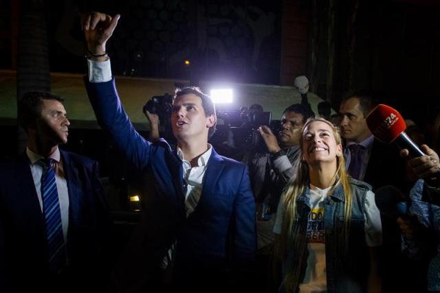 El líder del partido español Ciudadanos, Albert Rivera, y Lilian Tintori, esposa de   Leopoldo López, saludan al opositor encarcelado Daniel Ceballos a las afueras de su residencia en la ciudad de Caracas (Venezuela).  EFE