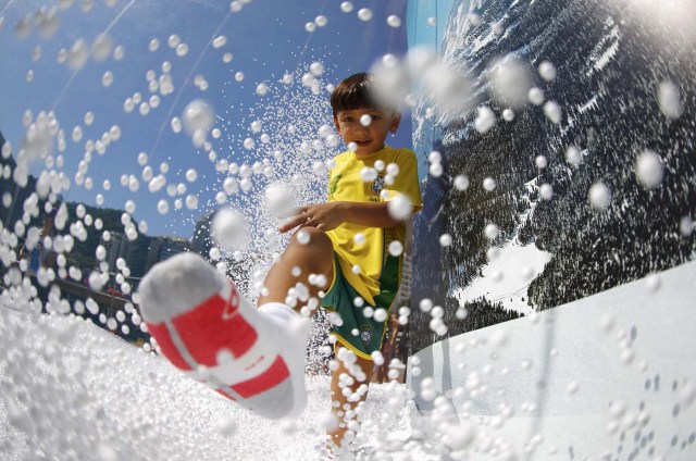 Rio Olympics - Lagoa - Rio de Janeiro, Brazil - 01/08/2016. A boy wears a Brazil football shirt as he plays in a display at the Switzerland house. REUTERS/Ivan Alvarado FOR EDITORIAL USE ONLY. NOT FOR SALE FOR MARKETING OR ADVERTISING CAMPAIGNS.