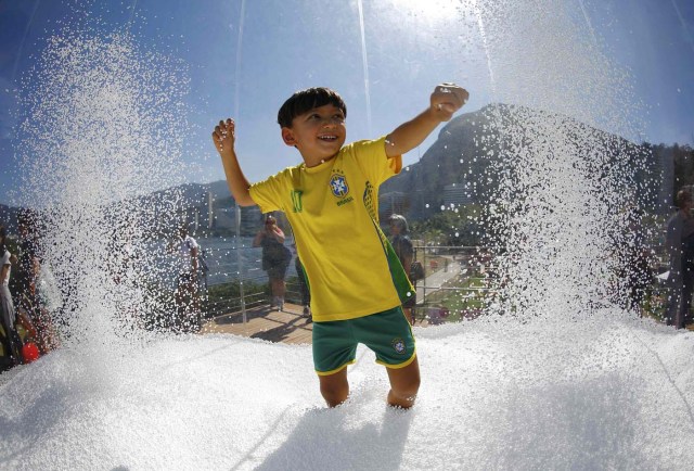 Rio Olympics - Lagoa - Rio de Janeiro, Brazil - 01/08/2016. A boy wears a Brazil football shirt as he plays in a display at the Switzerland house. REUTERS/Ivan Alvarado TPX IMAGES OF THE DAY FOR EDITORIAL USE ONLY. NOT FOR SALE FOR MARKETING OR ADVERTISING CAMPAIGNS.