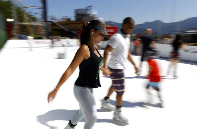 Rio Olympics - Lagoa - Rio de Janeiro, Brazil - 01/08/2016. People use adapted ice skates to skate on an artificial ice rink at the Switzerland house. REUTERS/Ivan Alvarado FOR EDITORIAL USE ONLY. NOT FOR SALE FOR MARKETING OR ADVERTISING CAMPAIGNS.