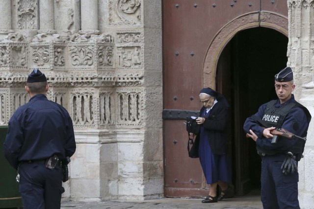 Armed French police stand guard as a nun leaves the Cathedral in Rouen after a funeral service in memory of slain French parish priest Father Jacques Hamel in Rouen, France, August 2, 2016.  Father Jacques Hamel was killed last week in an attack on a church at Saint-Etienne-du-Rouvray near Rouen that was carried out by assailants linked to Islamic State.   REUTERS/Jacky Naegelen