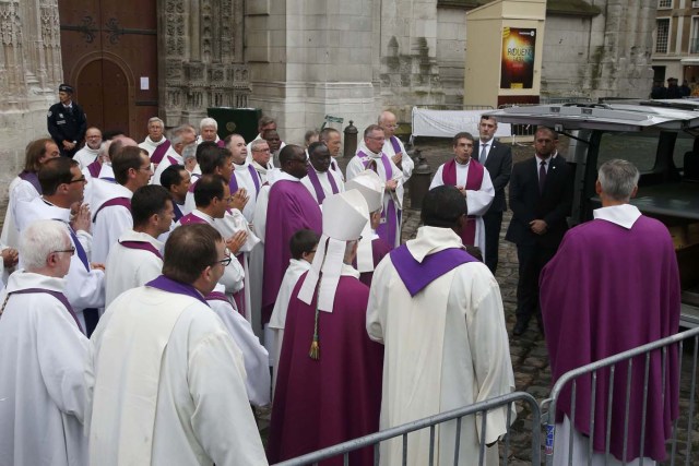 Religious leaders and priests gather near the hearse carrying the coffin of slain French parish priest Father Jacques Hamel after a funeral ceremony at the Cathedral in Rouen, France, August 2, 2016.  Father Jacques Hamel was killed last week in an attack on a church at Saint-Etienne-du-Rouvray near Rouen that was carried out by assailants linked to Islamic State.     REUTERS/Jacky Naegelen