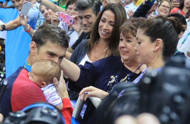 2016 Rio Olympics - Swimming - Victory Ceremony - Men's 200m Butterfly Victory Ceremony - Olympic Aquatics Stadium - Rio de Janeiro, Brazil - 09/08/2016. Michael Phelps (USA) of USA greets his mother Debbie, fiance Nicole Johnson and their son Boomer after he won the gold medal.   REUTERS/Dominic Ebenbichler FOR EDITORIAL USE ONLY. NOT FOR SALE FOR MARKETING OR ADVERTISING CAMPAIGNS.