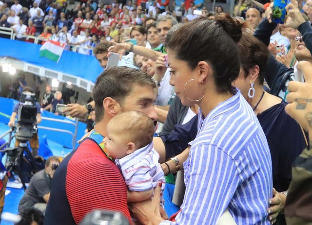 2016 Rio Olympics - Swimming - Victory Ceremony - Men's 200m Butterfly Victory Ceremony - Olympic Aquatics Stadium - Rio de Janeiro, Brazil - 09/08/2016. Michael Phelps (USA) of USA greets his mother Debbie, fiance Nicole Johnson and their son Boomer after he won the gold medal.   REUTERS/Dominic Ebenbichler FOR EDITORIAL USE ONLY. NOT FOR SALE FOR MARKETING OR ADVERTISING CAMPAIGNS.