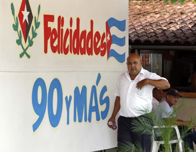 HAB101. LA HABANA (CUBA), 09/08/2016.- Un hombre pasa hoy, martes 09 de agosto del 2016, en La Habana (Cuba), junto a un mensaje alusivo al cumpleaños 90 del líder de la revolución cubana Fidel Castro este próximo sábado 13 de agosto. EFE/Ernesto Mastrascusa