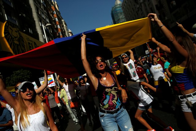 Protesters hold a Venezuelan flag during a demonstration to demand a referendum to remove Venezuela's President Nicolas Maduro, in Madrid, Spain September 4, 2016. REUTERS/Susana Vera