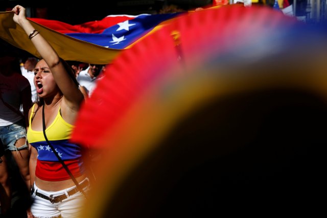 Protesters hold a Venezuelan flag during a demonstration to demand a referendum to remove Venezuela's President Nicolas Maduro, in Madrid, Spain, September 4, 2016. REUTERS/Susana Vera