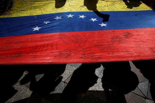 Protesters carry a Venezuelan flag during a demonstration to demand a referendum to remove Venezuela's President Nicolas Maduro, in Madrid, Spain, September 4, 2016. REUTERS/Susana Vera