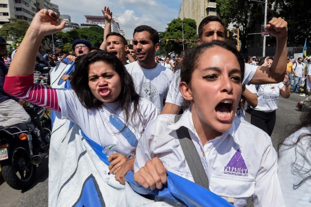 University students march against the government of Venezuelan President Nicolas Maduro in the streets of Caracas on October 26, 2016. Venezuela's political rivals are set to engage in a volatile test of strength on Wednesday, with the opposition vowing mass street protests as President Nicolas Maduro resists efforts to drive him from power. The socialist president and center-right-dominated opposition accuse each other of mounting a "coup" in a volatile country rich in oil but short of food. / AFP PHOTO / Juan BARRETO