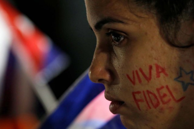 A woman with the writing "Fidel lives" on her cheek participates in a massive tribute to Cuba's late President Fidel Castro on Revolution Square in Havana, Cuba, November 29, 2016. REUTERS/Stringer EDITORIAL USE ONLY. NO RESALES. NO ARCHIVE TPX IMAGES OF THE DAY