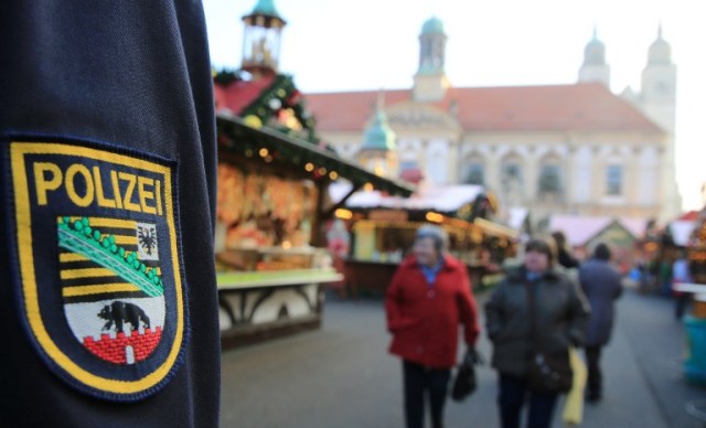 Policemen patrol over a Christmas market in Magdeburg, eastern Germany, on December 20, 2016, as security measures are taken after a deadly rampage by a lorry driver at a Berlin Christmas market. German Chancellor Angela Merkel said that authorities believe the rampage, killing 12, was a "terrorist" attack likely committed by an asylum seeker. / AFP PHOTO / dpa / Peter Gercke / Germany OUT