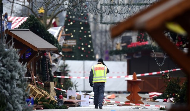 A policeman walks at the Christmas market near the Kaiser-Wilhelm-Gedaechtniskirche (Kaiser Wilhelm Memorial Church), the day after a terror attack, in central Berlin, on December 20, 2016. German police said they were treating as "a probable terrorist attack" the killing of 12 people when the speeding lorry cut a bloody swath through the packed Berlin Christmas market. / AFP PHOTO / Tobias SCHWARZ