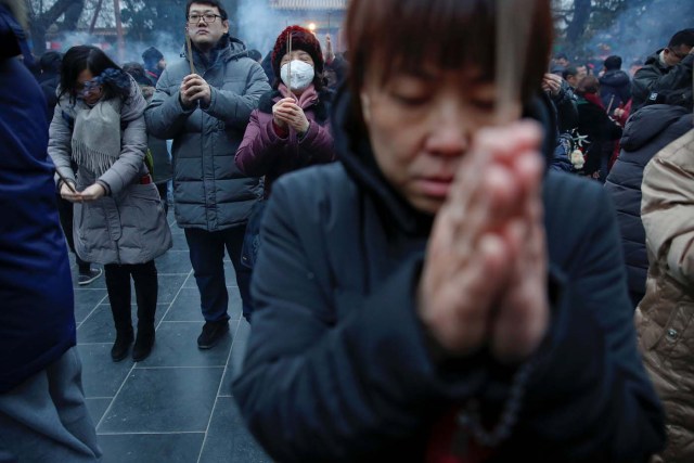 People burn incense sticks and pray for good fortune at Yonghegong Lama Temple on the first day of the Lunar New Year of the Rooster in Beijing, China January 28, 2017. REUTERS/Damir Sagolj