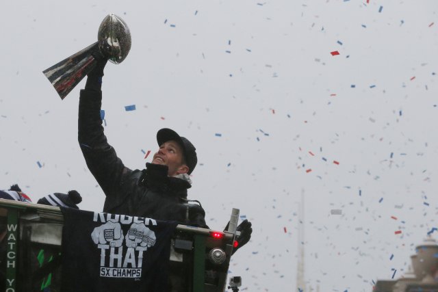 New England Patriots quarterback Tom Brady holds up one of the team's five Vince Lombardi trophies during their victory parade through the streets of Boston after winning Super Bowl LI, in Boston