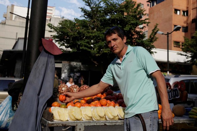 Jesus Pena sells fruits at his stall in a street of Chacao, in Caracas, Venezuela February 24, 2017. Picture taken February 24, 2017. REUTERS/Marco Bello