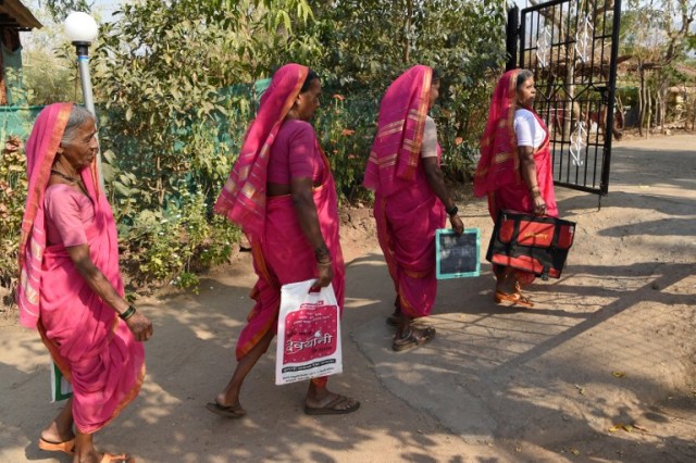 This photo taken on March 1, 2017 shows Indian women leaving a class from Aajibaichi Shala, or "school for grannies" in the local Marathi language, in Phangane village in Maharashtra state's Thane district, some 125km northeast of Mumbai. They wear uniforms, carry satchels, and eagerly recite the alphabet in class, but the students here are different -- this is a "school for grannies". Deprived of an education as children, the women -- most of whom are widows and aged between 60 and 90 -- are finally fulfilling a life-long dream to become literate through this unique initiative near Mumbai. / AFP PHOTO / Indranil MUKHERJEE / TO GO WITH "India-education-women-school,FEATURE" by Peter HUTCHISON