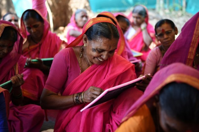 This photo taken on March 1, 2017 shows Indian grandmother Savita Deshmukh (C), 62, during class at the Aajibaichi Shala, or "school for grannies" in the local Marathi language, in Phangane village in Maharashtra state's Thane district, some 125km northeast of Mumbai. They wear uniforms, carry satchels, and eagerly recite the alphabet in class, but the students here are different -- this is a "school for grannies". Deprived of an education as children, the women -- most of whom are widows and aged between 60 and 90 -- are finally fulfilling a life-long dream to become literate through this unique initiative near Mumbai. / AFP PHOTO / Indranil MUKHERJEE / TO GO WITH "India-education-women-school,FEATURE" by Peter HUTCHISON