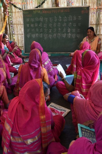 This photo taken on March 1, 2017 shows women attending class at Aajibaichi Shala, or "school for grannies" in the local Marathi language, in Phangane village in Maharashtra state's Thane district, some 125km northeast of Mumbai. They wear uniforms, carry satchels, and eagerly recite the alphabet in class, but the students here are different -- this is a "school for grannies". Deprived of an education as children, the women -- most of whom are widows and aged between 60 and 90 -- are finally fulfilling a life-long dream to become literate through this unique initiative near Mumbai. / AFP PHOTO / Indranil MUKHERJEE / TO GO WITH "India-education-women-school,FEATURE" by Peter HUTCHISON