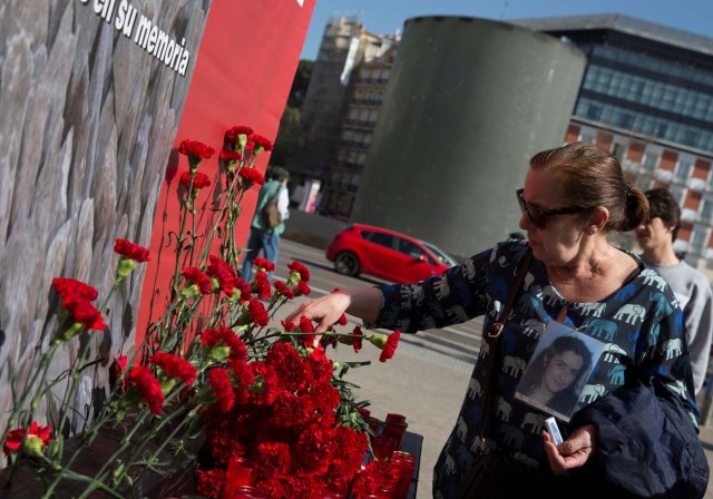 A relative of a victim of the Madrid train attacks places a flower outside Atocha station on the 13th anniversary of the attacks in Madrid, Spain, March 11, 2017. REUTERS/Sergio Perez