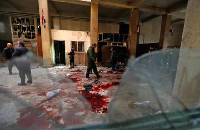 Syrian security forces inspect the scene of a reported suicide bombing at the old palace of justice building in Damascus on March 15, 2017. Two suicide bombings hit Damascus including the attack at the central courthouse that left at least 32 dead, as Syria's war entered its seventh year with the regime now claiming the upper hand. / AFP PHOTO / Louai Beshara