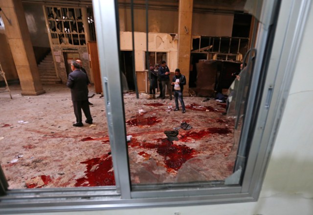 Syrian security forces and journalists stand inside the old palace of justice building in Damascus following a reported suicide bombing on March 15, 2017. Two suicide bombings hit Damascus including the attack at the central courthouse that left at least 32 dead, as Syria's war entered its seventh year with the regime now claiming the upper hand. / AFP PHOTO / Louai Beshara