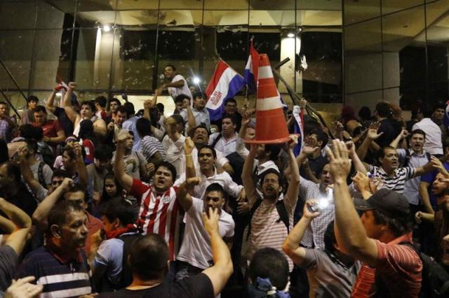 Manifestantes atacan hoy, viernes 31 de marzo de 2017, la sede del Congreso Nacional en Asunción (Paraguay). EFE