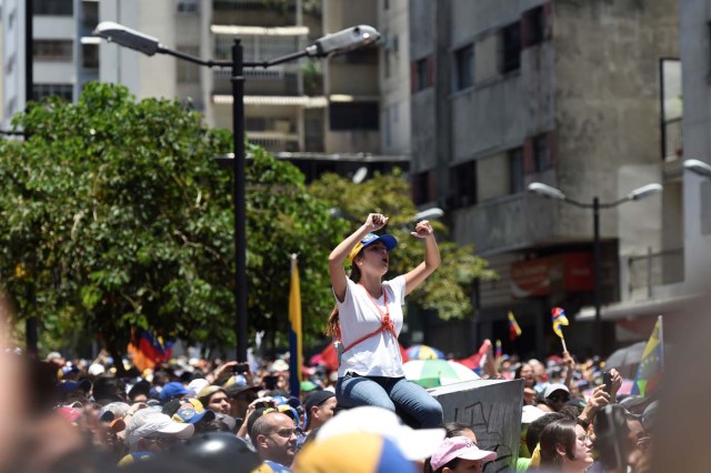 Demonstrators against Nicolas Maduro's government gather in Caracas on April 8, 2017. The opposition is accusing pro-Maduro Supreme Court judges of attempting an internal "coup d'etat" for attempting to take over the opposition-majority legislature's powers last week. The socialist president's supporters held counter-demonstrations on Thursday, condemning Maduro's opponents as "imperialists" plotting with the United States to oust him. / AFP PHOTO / JUAN BARRETO