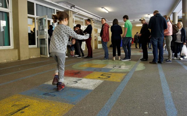 A girl plays hopscotch as people line up to vote in the first round of 2017 French presidential election at a polling station in Marseille, France, April 23, 2017. REUTERS/Philippe Laurenson     TPX IMAGES OF THE DAY