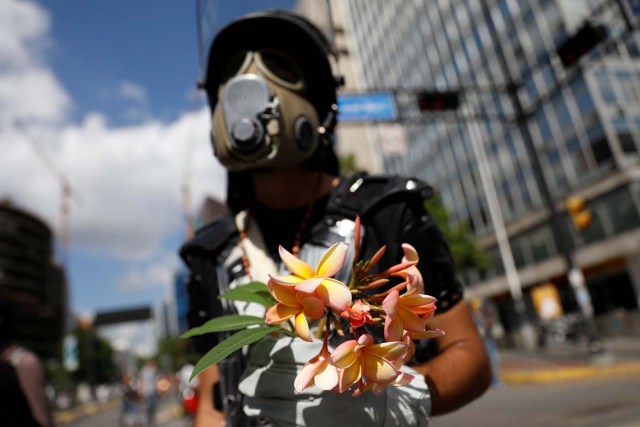 An opposition supporter holds a bouquet of flowers during a rally against Venezuela's President Nicolas Maduro in Caracas, Venezuela May 20, 2017. REUTERS/Carlos Garcia Rawlins